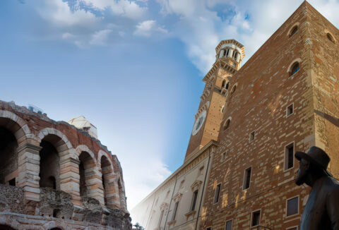 Arcadas del anfiteatro Arena de Verona y estatua de bronce en la bella Plaza Delle Erbe
